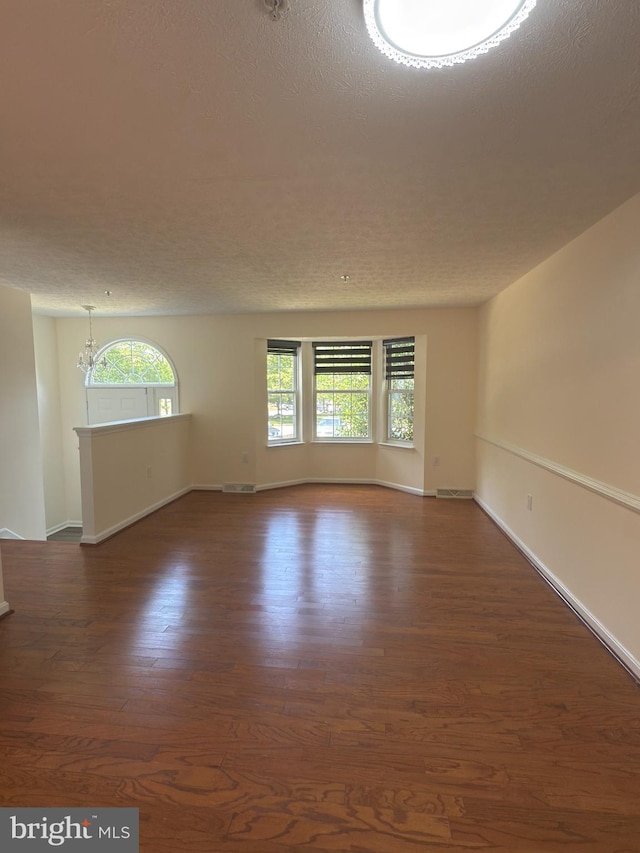4407 Stanford Ct, Owings Mills, MD 21117 - unfurnished room with wood finished floors, a textured ceiling, and a chandelier