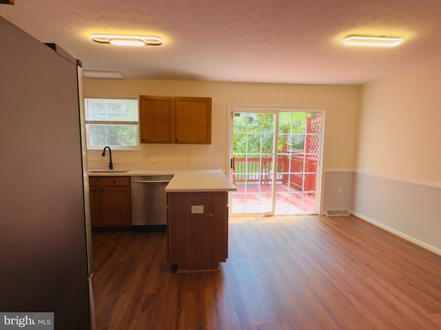 4407 Stanford Ct, Owings Mills, MD 21117 - kitchen featuring appliances with stainless steel finishes, dark wood-style floors, light countertops, a textured ceiling, and brown cabinets