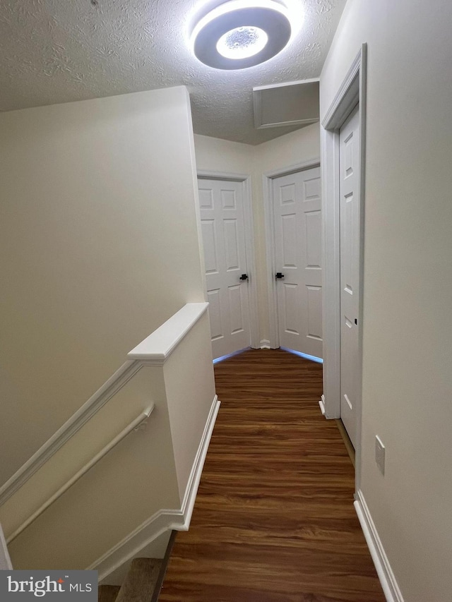 4407 Stanford Ct, Owings Mills, MD 21117 - hallway with dark wood finished floors, a textured ceiling, and an upstairs landing