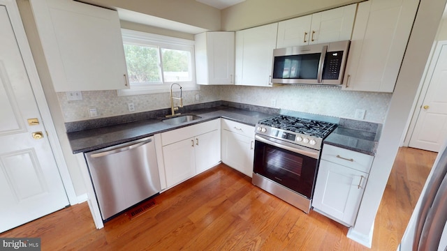 1412 Glassboro Rd, Wenonah, NJ 08090 - kitchen with stainless steel appliances, dark countertops, light wood finished floors, and white cabinetry