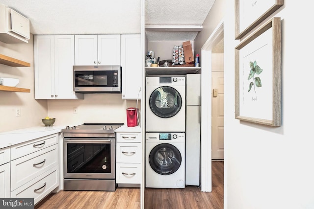 15101 Interlachen Dr Unit 1-126, Silver Spring, MD 20906 - laundry area with stacked washer / drying machine, wood finished floors, and a textured ceiling