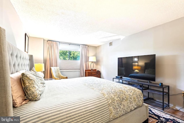 15101 Interlachen Dr Unit 1-126, Silver Spring, MD 20906 - bedroom featuring a textured ceiling and wood finished floors