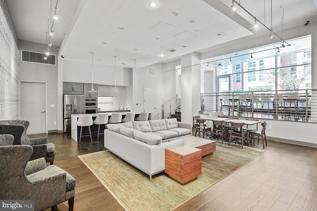 1025 1st St SE Unit 809, Washington, DC 20003 - living room featuring dark wood-type flooring, track lighting, a high ceiling, and stairway