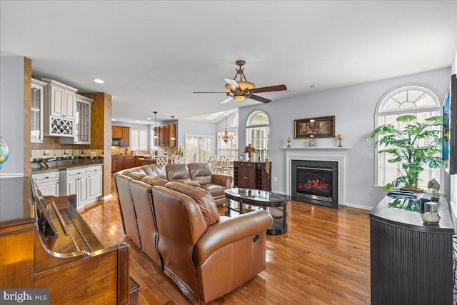 102 Windsor, Swedesboro, NJ 08085 - living room with a ceiling fan, wood finished floors, a glass covered fireplace, recessed lighting, and a chandelier