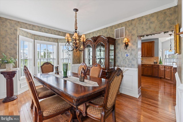 102 Windsor, Swedesboro, NJ 08085 - dining room featuring wallpapered walls, healthy amount of natural light, a chandelier, light wood-type flooring, and wainscoting
