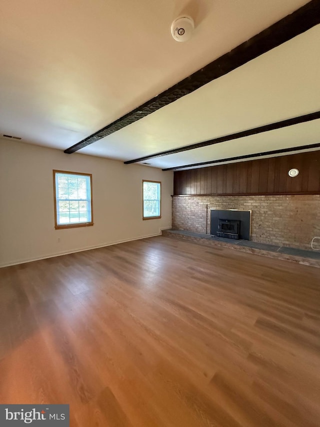 12130 Ambleside Dr, Potomac, MD 20854 - unfurnished living room with a fireplace, beam ceiling, and wood finished floors