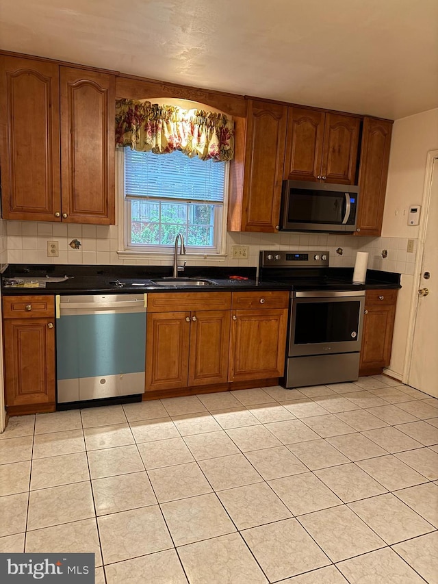 12130 Ambleside Dr, Potomac, MD 20854 - kitchen with stainless steel appliances, dark countertops, and brown cabinets