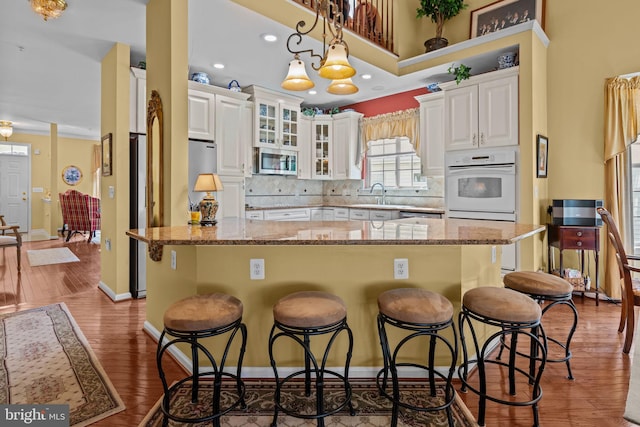 945 Hamilton Way, Warwick, PA 18974 - kitchen featuring oven, stainless steel microwave, white cabinetry, a kitchen breakfast bar, and recessed lighting