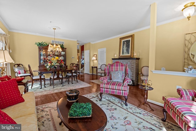 945 Hamilton Way, Warwick, PA 18974 - living area with wood finished floors, a chandelier, crown molding, and a brick fireplace