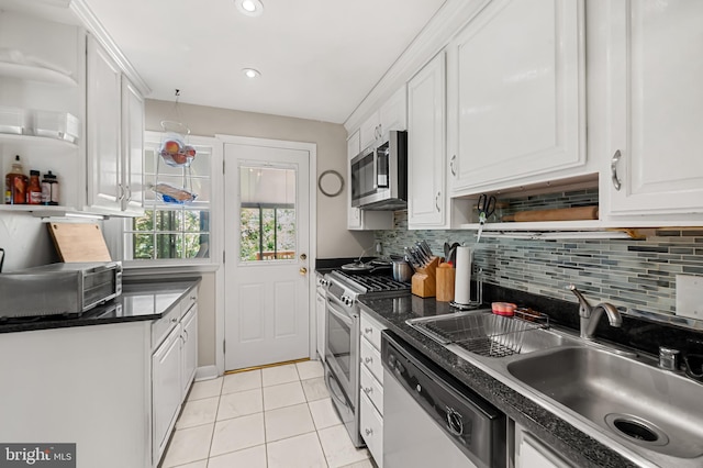 808 Olmstead Rd, Baltimore, MD 21208 - kitchen featuring appliances with stainless steel finishes, dark countertops, white cabinets, open shelves, and decorative backsplash