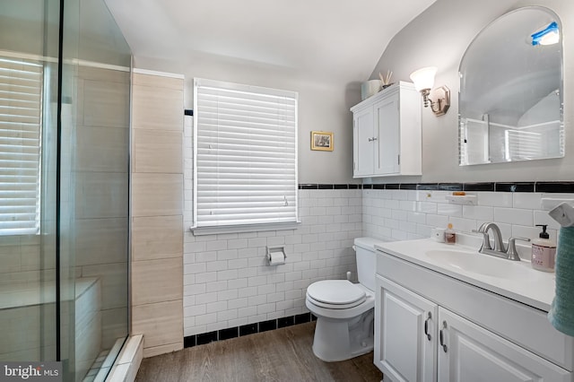 808 Olmstead Rd, Baltimore, MD 21208 - bathroom with tile walls, vanity, wood finished floors, a stall shower, and a wainscoted wall