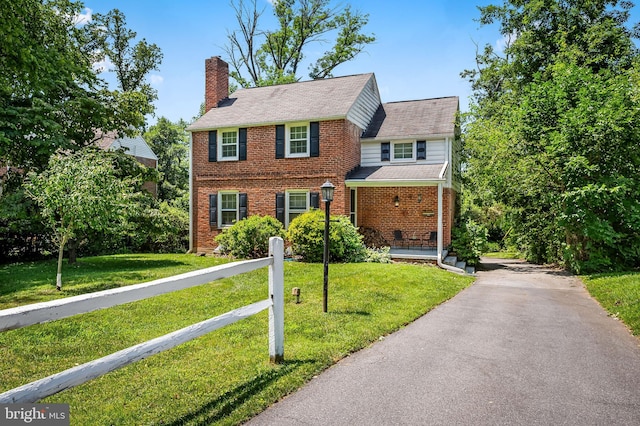 808 Olmstead Rd, Baltimore, MD 21208 - view of front of property with brick siding, a chimney, a porch, and a front lawn
