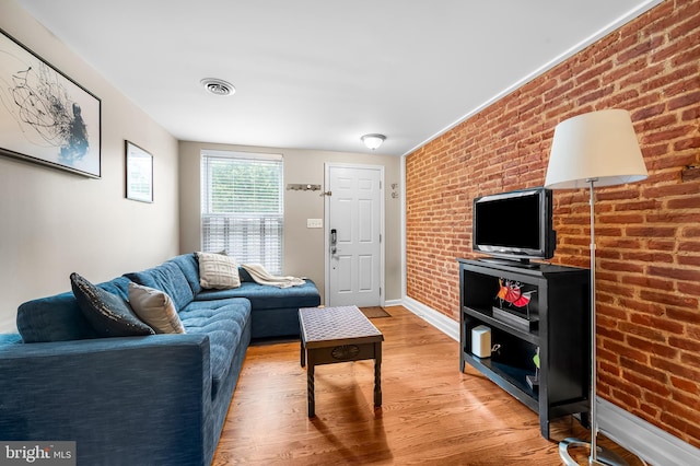 2503 Eastern Ave, Baltimore, MD 21224 - living room featuring light wood-style flooring and brick wall