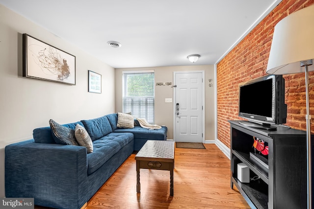 2503 Eastern Ave, Baltimore, MD 21224 - living room featuring light wood-style flooring and brick wall