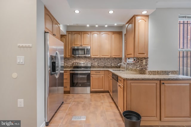 1458 Columbia Rd NW Unit 109, Washington, DC 20009 - kitchen featuring appliances with stainless steel finishes, light stone counters, decorative backsplash, light tile patterned flooring, and light brown cabinetry