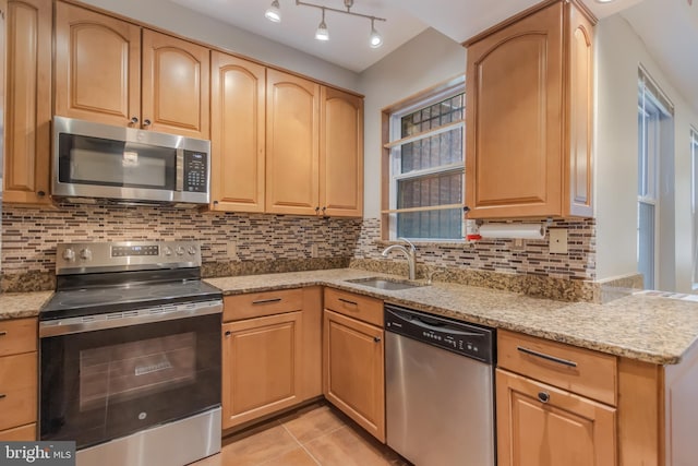 1458 Columbia Rd NW Unit 109, Washington, DC 20009 - kitchen with appliances with stainless steel finishes, light stone counters, light brown cabinets, decorative backsplash, and light tile patterned floors