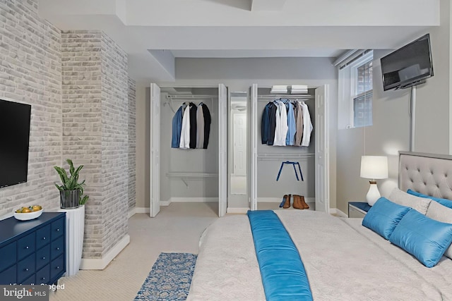 1458 Columbia Rd NW Unit 109, Washington, DC 20009 - bedroom featuring light carpet, two closets, and brick wall