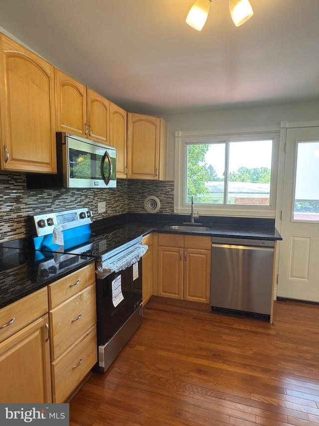 1233 Knightswood Rd, Baltimore, MD 21239 - kitchen with appliances with stainless steel finishes, dark countertops, dark wood-type flooring, decorative backsplash, and light brown cabinetry