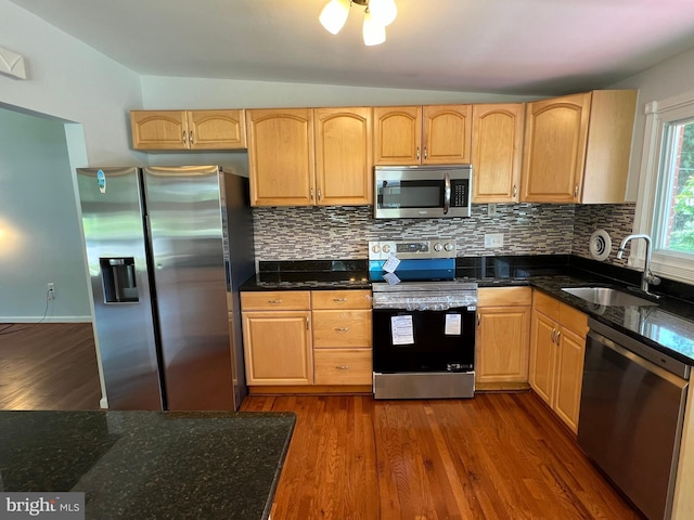 1233 Knightswood Rd, Baltimore, MD 21239 - kitchen with appliances with stainless steel finishes, dark wood-style flooring, decorative backsplash, and dark stone counters