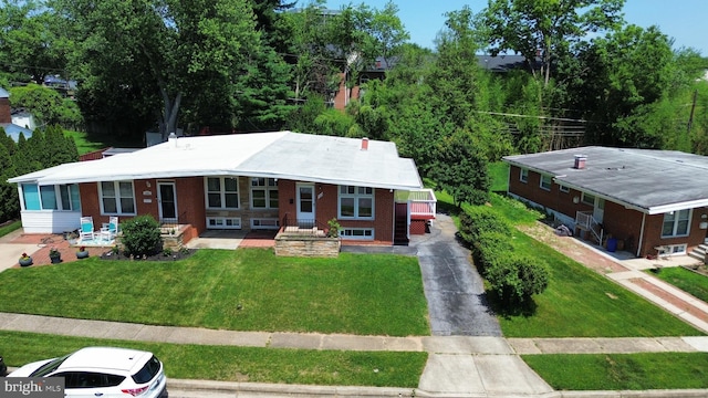 1233 Knightswood Rd, Baltimore, MD 21239 - view of front facade featuring brick siding, a front yard, and asphalt driveway