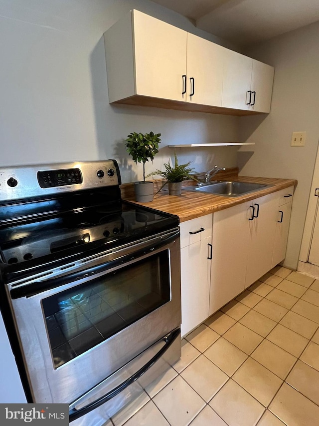 1233 Knightswood Rd, Baltimore, MD 21239 - kitchen featuring stainless steel electric stove, white cabinets, and light tile patterned floors