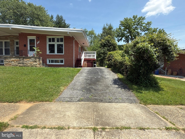 1233 Knightswood Rd, Baltimore, MD 21239 - view of front facade featuring brick siding, a front lawn, and asphalt driveway