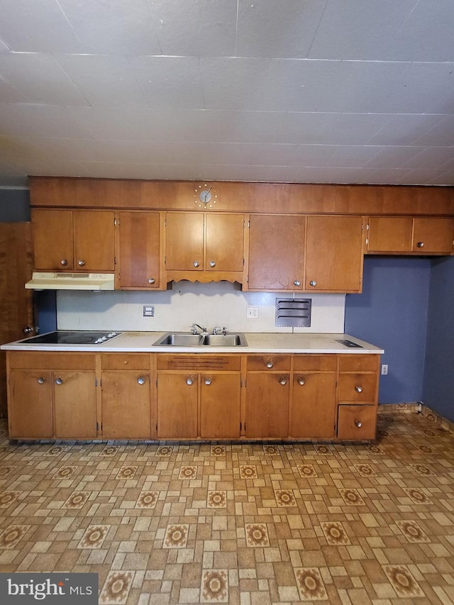 542 S 14 1/2 St, Reading, PA 19602 - kitchen featuring brown cabinetry, under cabinet range hood, black electric stovetop, and light countertops