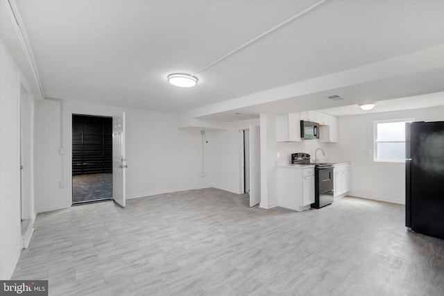 1221 W Heiges St, York, PA 17404 - kitchen featuring black appliances, white cabinetry, light countertops, and open floor plan