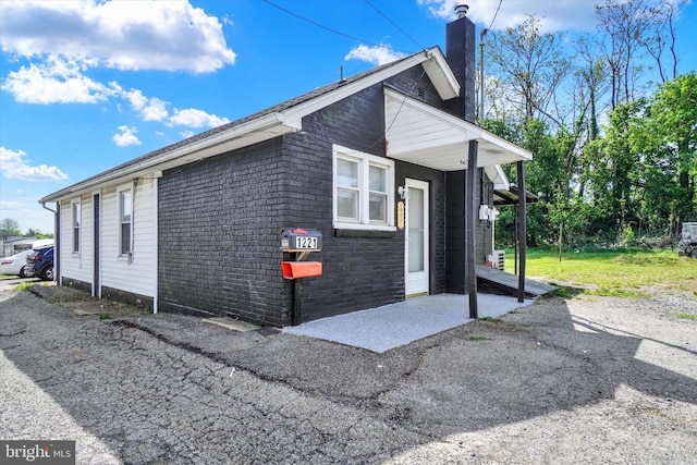 1221 W Heiges St, York, PA 17404 - view of home's exterior with a chimney and brick siding