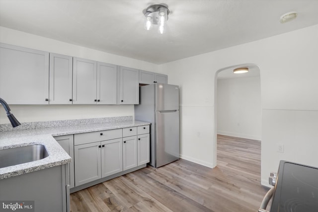 1221 W Heiges St, York, PA 17404 - kitchen with freestanding refrigerator, light wood-style flooring, range, and light stone countertops