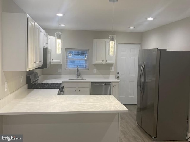 224 N Rose St, Baltimore, MD 21224 - kitchen with stainless steel appliances, a peninsula, light countertops, recessed lighting, and light wood-style floors