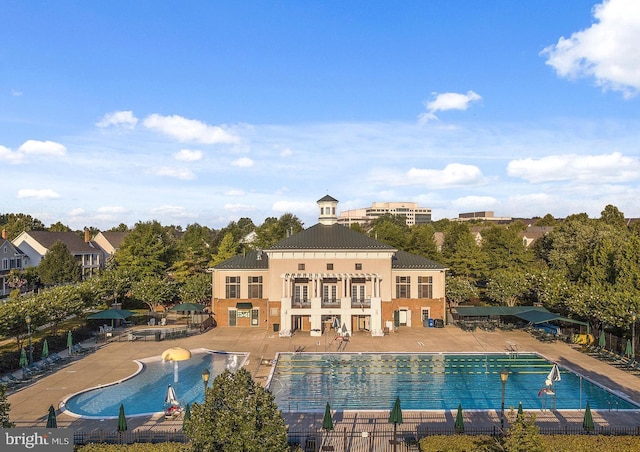 845 King Farm Blvd, Rockville, MD 20850 - rear view of house with a community pool, a patio, a metal roof, and stucco siding