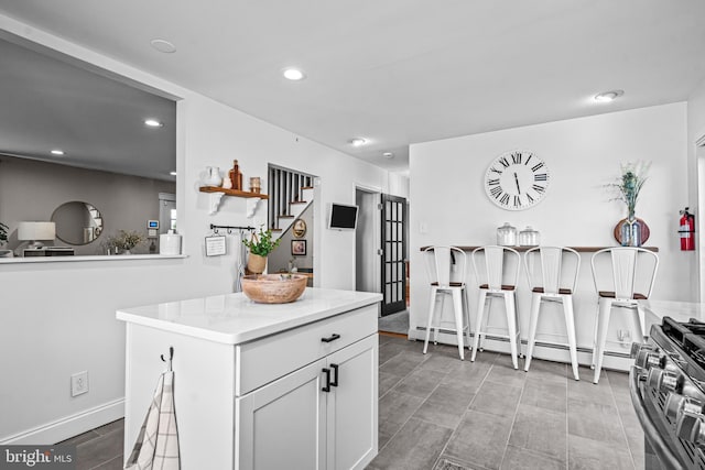 69 Plymouth Rd, Sicklerville, NJ 08081 - kitchen featuring stainless steel range with gas stovetop, recessed lighting, light countertops, white cabinetry, and a baseboard heating unit