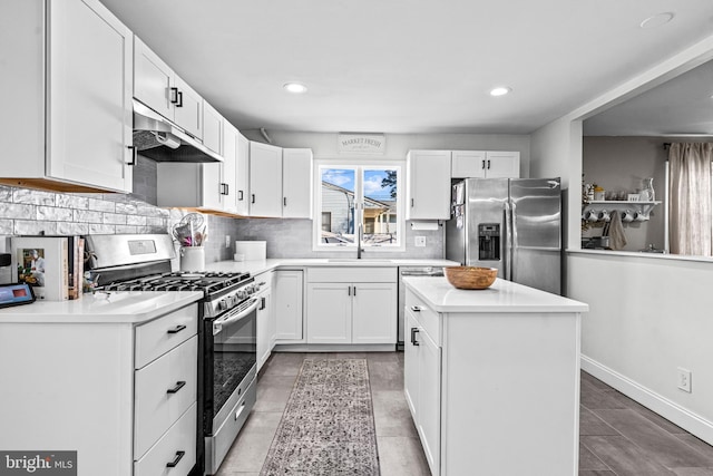 69 Plymouth Rd, Sicklerville, NJ 08081 - kitchen with appliances with stainless steel finishes, under cabinet range hood, backsplash, white cabinets, and recessed lighting
