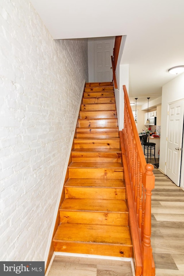 16 S Kresson St, Baltimore, MD 21224 - staircase featuring wood finished floors and brick wall
