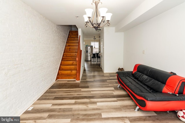 16 S Kresson St, Baltimore, MD 21224 - living area with wood finished floors, a chandelier, stairs, and brick wall
