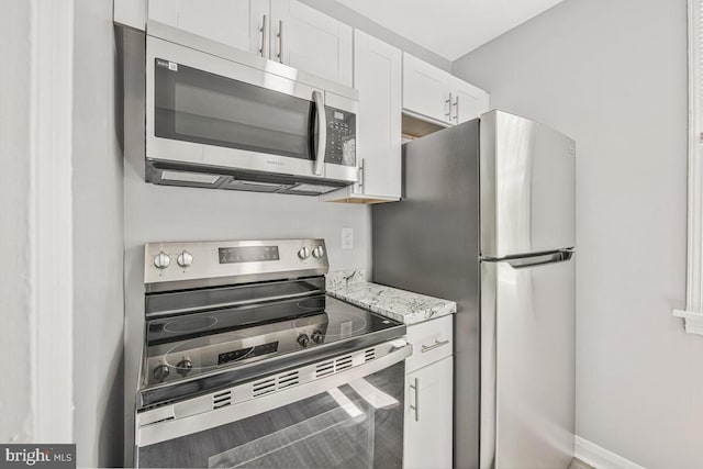 1112 Gleneagle Rd, Baltimore, MD 21239 - kitchen with appliances with stainless steel finishes, white cabinets, and light stone countertops