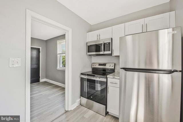 1112 Gleneagle Rd, Baltimore, MD 21239 - kitchen featuring appliances with stainless steel finishes, white cabinets, and light wood-type flooring