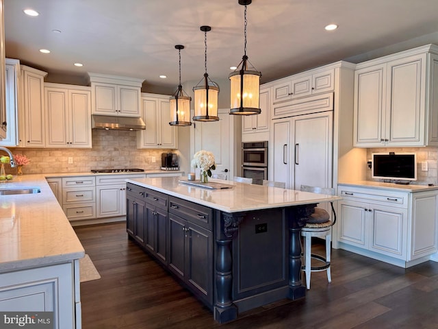 306 Rowland Ln, Line Lexington, PA 18932 - kitchen featuring gas stovetop, stainless steel double oven, under cabinet range hood, tasteful backsplash, and a kitchen island