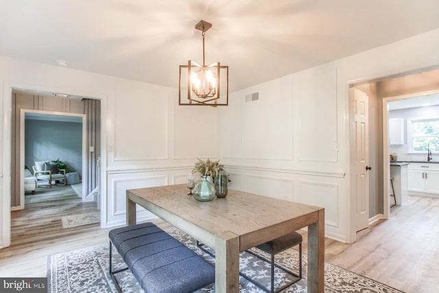 128 Azalea Dr, Hershey, PA 17033 - dining room with a decorative wall, a chandelier, and light wood finished floors
