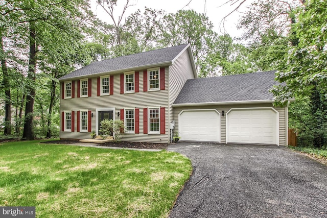 128 Azalea Dr, Hershey, PA 17033 - colonial house featuring a garage, asphalt driveway, a front lawn, and roof with shingles