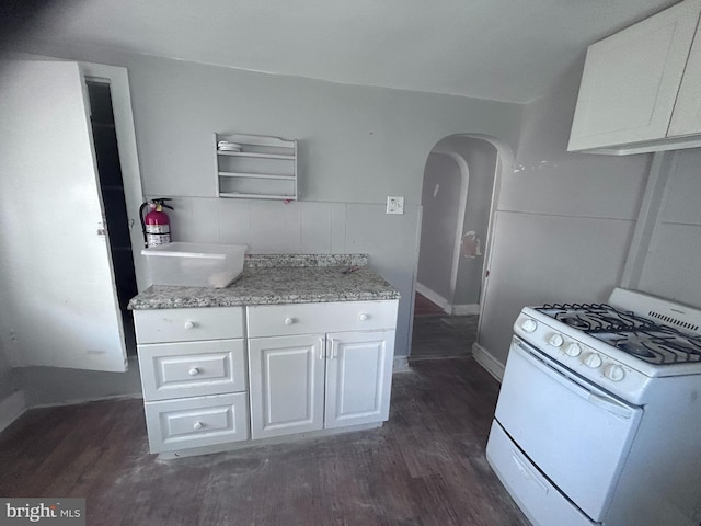 723 N Broad St, Woodbury, NJ 08096 - kitchen with white gas stove, dark wood-style floors, arched walkways, white cabinets, and open shelves