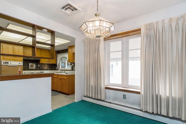 1402 Lehigh St, Allentown, PA 18103 - kitchen with a baseboard radiator, a chandelier, brown cabinetry, hanging light fixtures, and tasteful backsplash