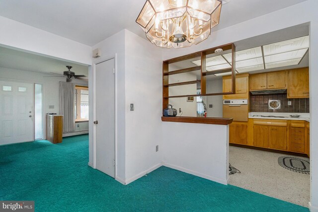 1402 Lehigh St, Allentown, PA 18103 - kitchen featuring oven, decorative backsplash, a chandelier, a ceiling fan, and cooktop