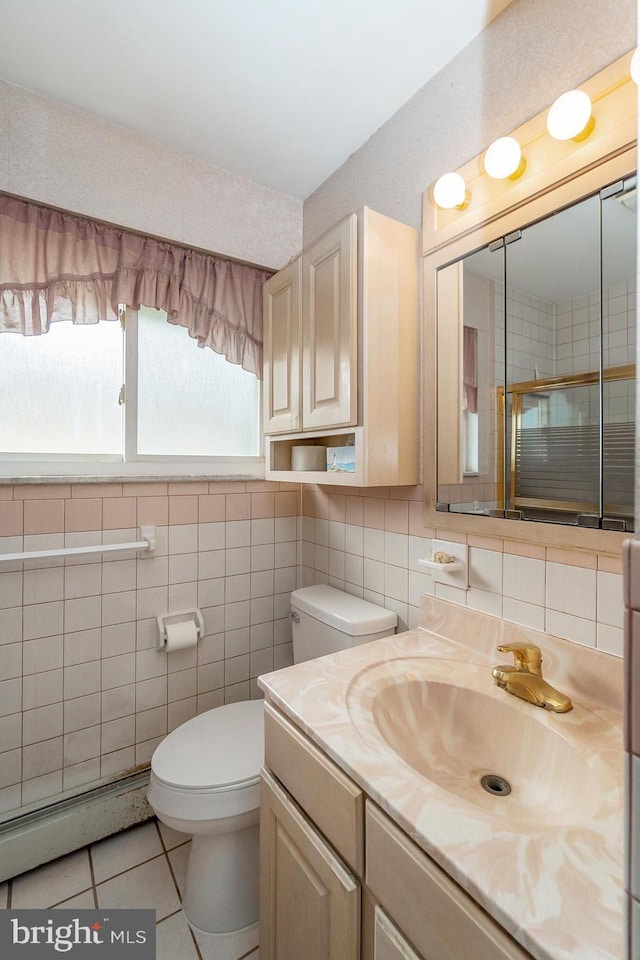 1402 Lehigh St, Allentown, PA 18103 - full bathroom with baseboard heating, vanity, tile patterned flooring, tile walls, and a shower with door