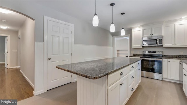 2705 W Gordon, Allentown, PA 18104 - kitchen with appliances with stainless steel finishes, arched walkways, a center island, white cabinetry, and dark stone countertops