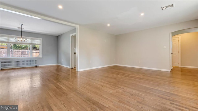 2705 W Gordon, Allentown, PA 18104 - spare room with radiator heating unit, arched walkways, light wood-type flooring, a chandelier, and recessed lighting
