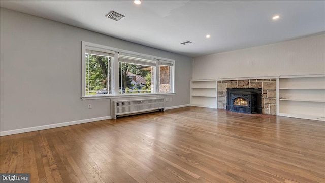 2705 W Gordon, Allentown, PA 18104 - unfurnished living room with radiator heating unit, wood finished floors, recessed lighting, a tile fireplace, and built in shelves