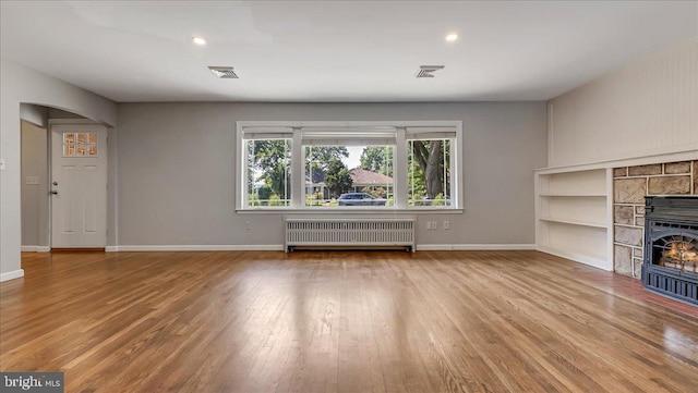 2705 W Gordon, Allentown, PA 18104 - unfurnished living room with radiator heating unit, wood finished floors, recessed lighting, arched walkways, and a fireplace