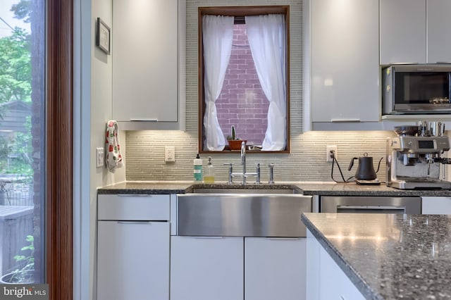 662 W Chestnut St, Lancaster, PA 17603 - kitchen featuring stainless steel microwave, tasteful backsplash, and white cabinetry